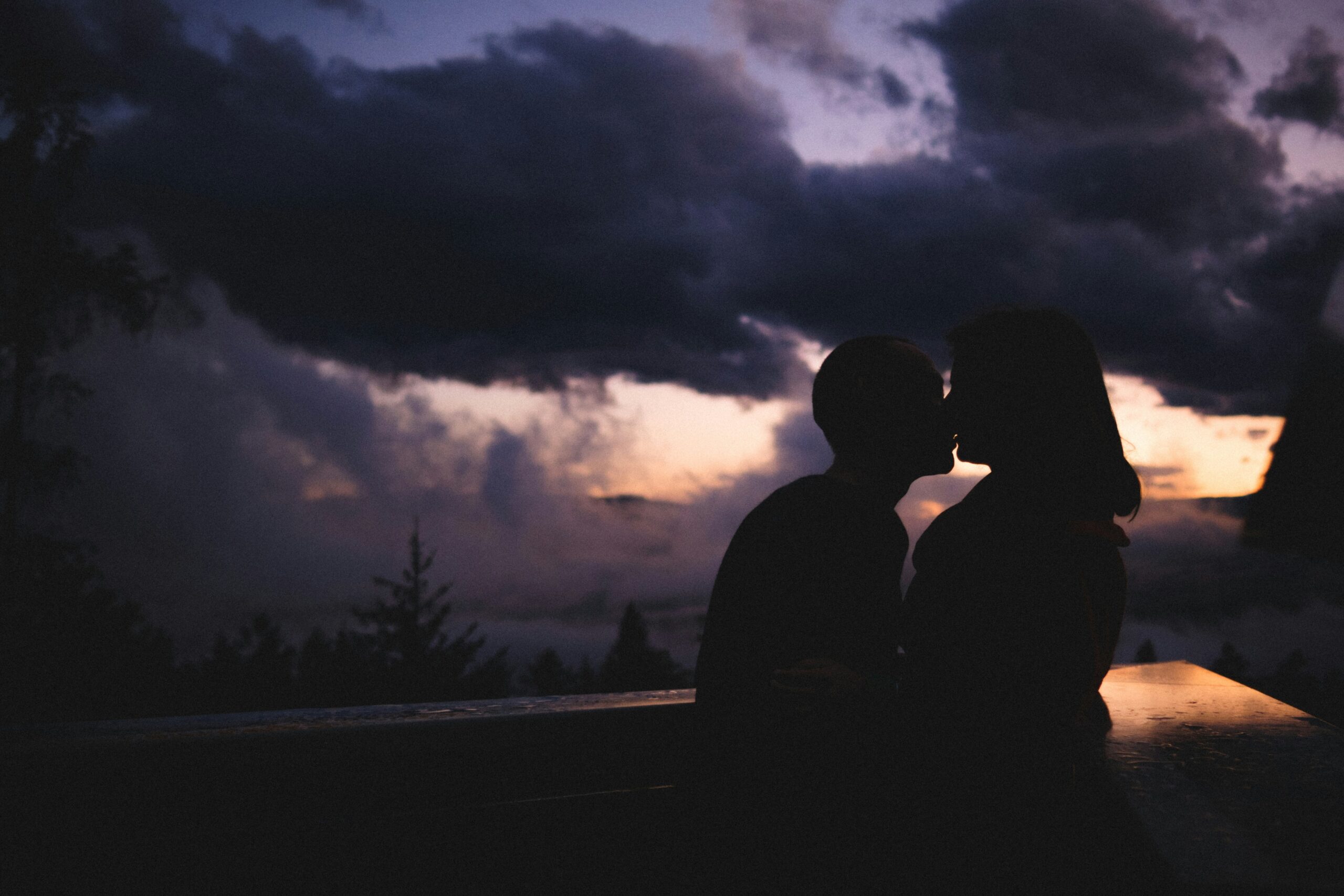 silhouette of man and woman standing on road during night time